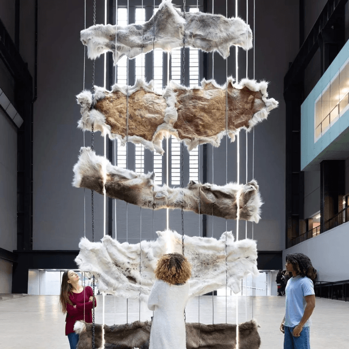 Visitors viewing a suspended installation in a gallery space