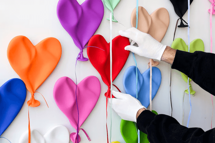 Heart shaped balloon artwork being installed on a wall